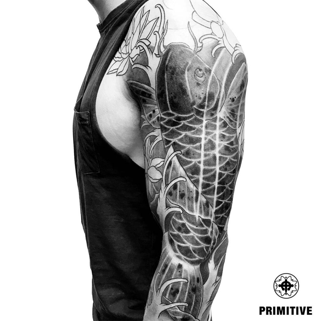 Black and grey Koi fish tattoo on back shoulder