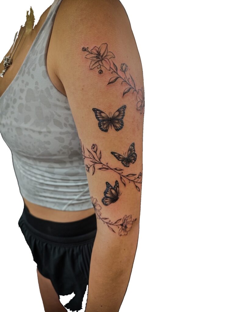 Fine line floral and butterfly arm tattoo